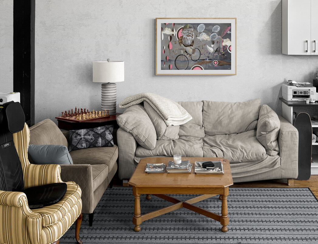 A cozy living room featuring Beyond Ice Cream Island by Prodigi, an abstract artwork on Hahnemühle German Etching giclée paper, displayed above a light gray sofa with striped armchair, wooden coffee table, lamp, and chess set.
