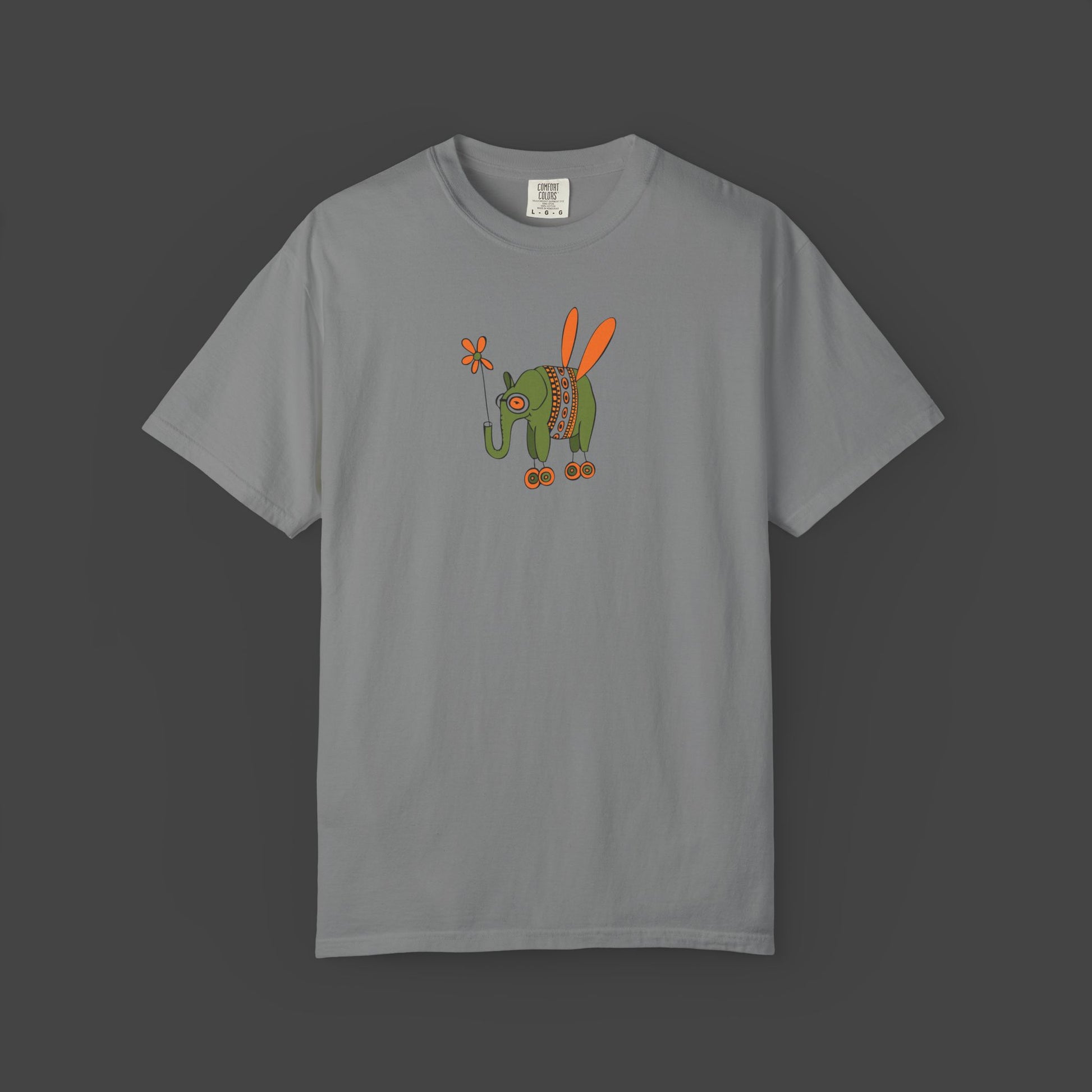 The Flying Elephant Unisex T-shirt by Printify features Jarrod Eastmans playful graphic of a green elephant with orange wings, roller skates, and a flower—an irresistibly whimsical tee for fans of fun, inspiring style.
