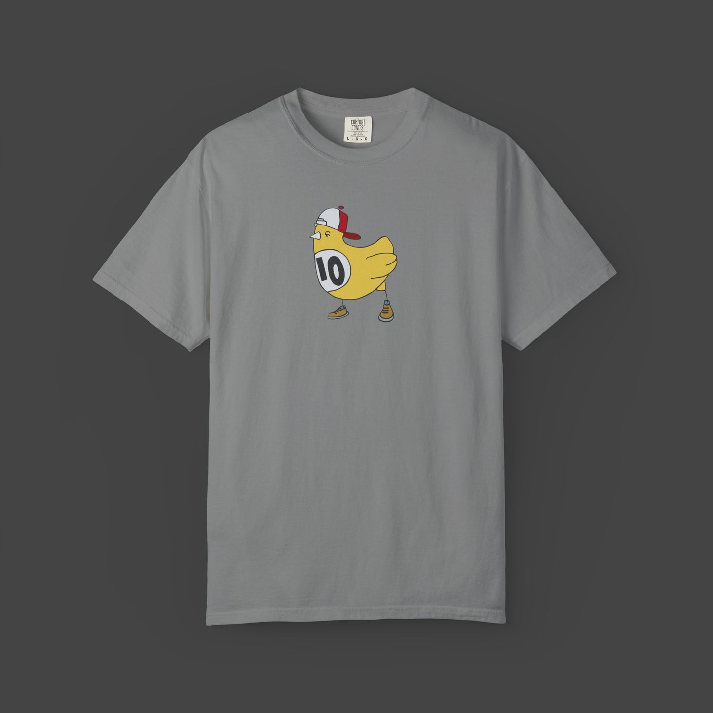 The Chicken Scratch Unisex T-shirt by Jarrod Eastman from Printify features a quirky, surreal cartoon yellow bird in a cap, brown shoes, and a #10 white jersey on a gray tee—fun art style centered on the front.