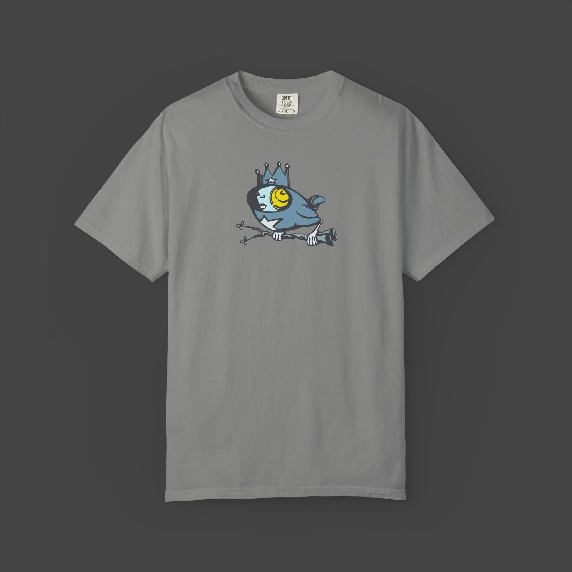 The Biddy Unisex T-shirt by Jarrod Eastman features a quirky surreal bird cartoon with a crown and bold yellow eye