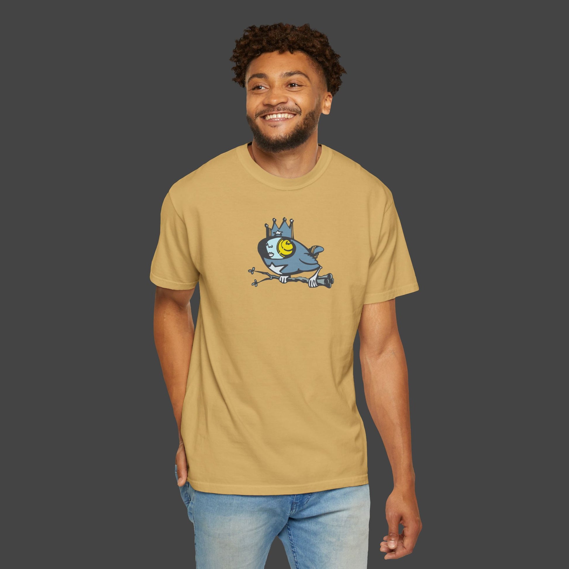 A smiling man with short curly hair wears the Biddy Surreal Bird Unisex T-shirt by Jarrod Eastman 