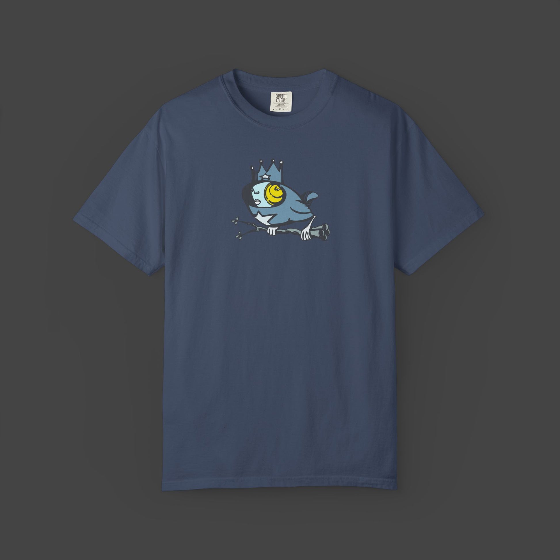 Biddy is a surreal bird unisex T-shirt by Jarrod Eastman. A whimsical blue bird with a human-like face, wearing a crown and holding a branch with its claws.