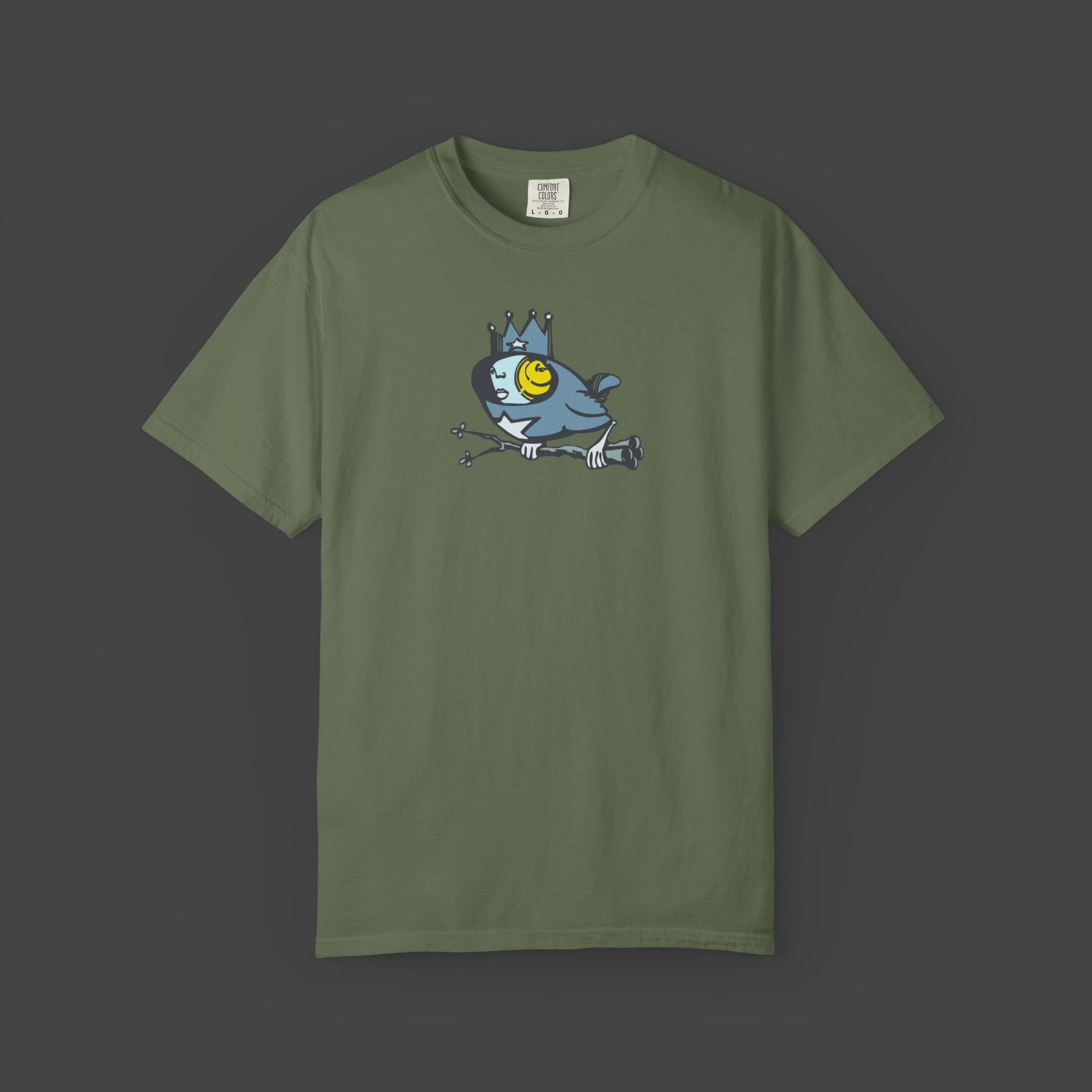 Biddy Surreal Bird Unisex T-shirt in green by Jarrod Eastman. A whimsical blue bird with a human-like face, wearing a crown and holding a branch with its claws.