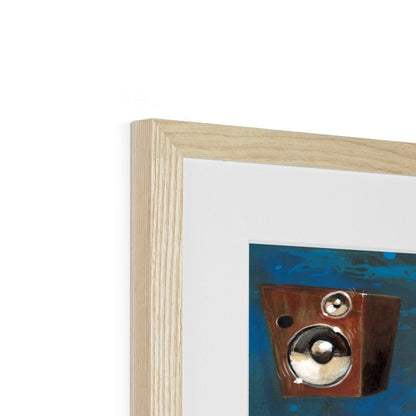 Close-up of the top left corner of a light wood  frame displaying Preaching to the Choir, abstract art with a brown box and metallic circles on a blue background.
