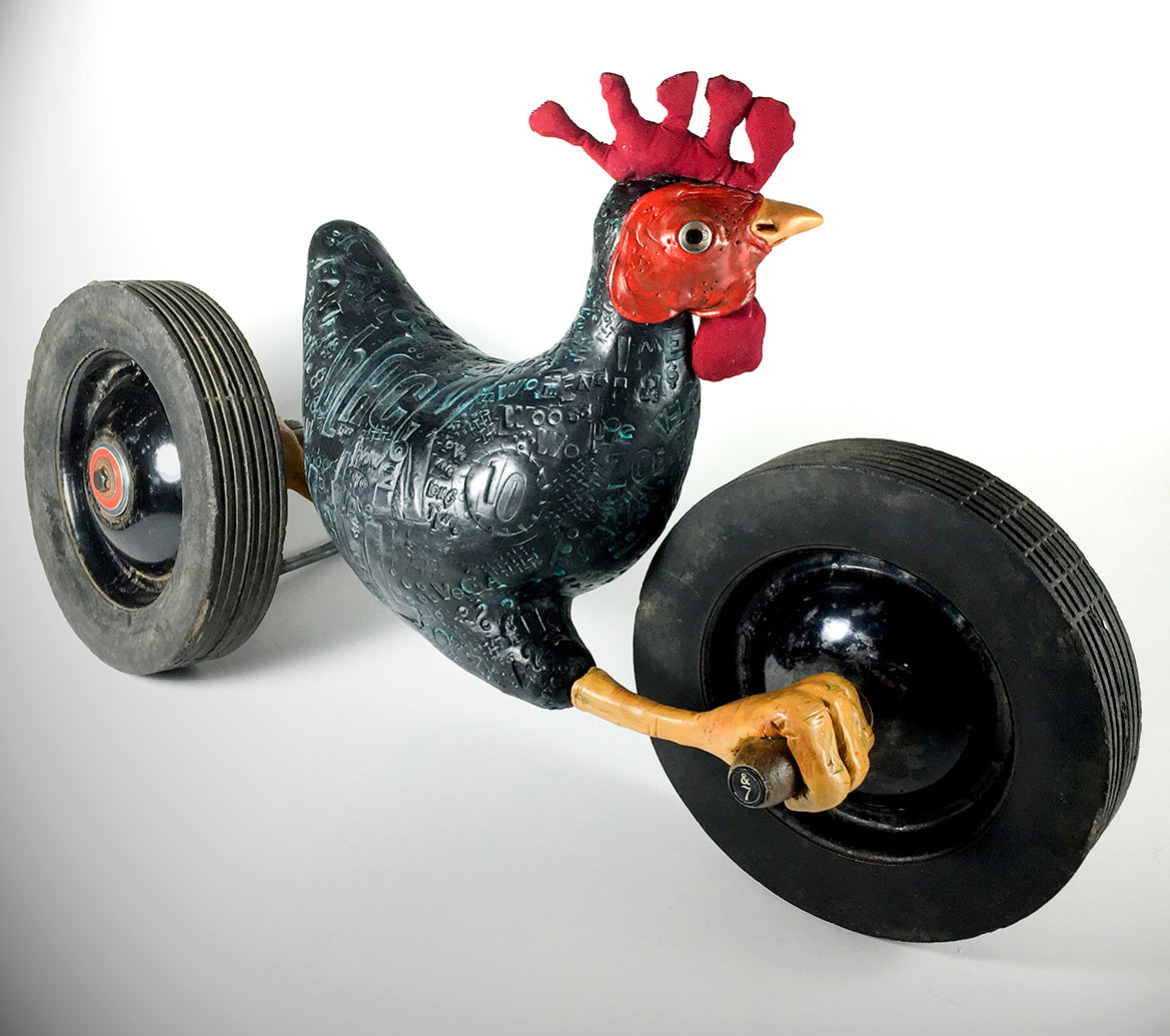 The jarrodeastman Black Chicken is a whimsical sculpture featuring a black chicken with a red comb and yellow beak, mounted on two large antique wheels for a playful, cart-like look.